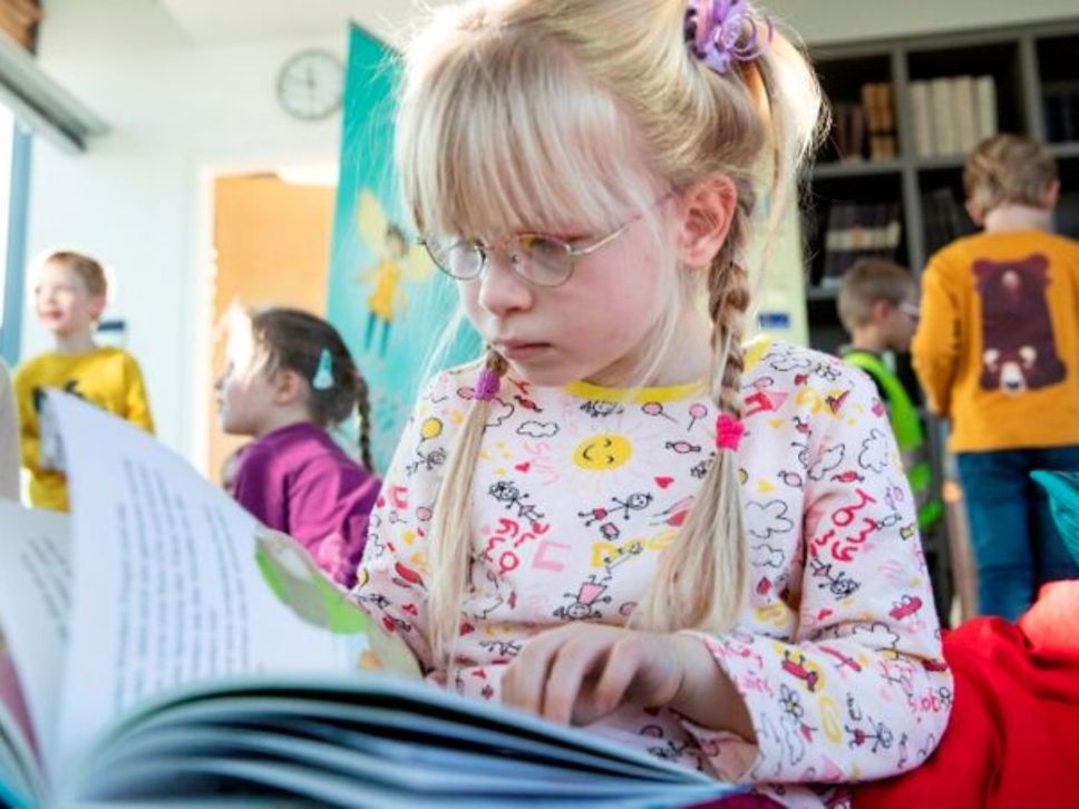 Mädchen liest in Kinderbuch