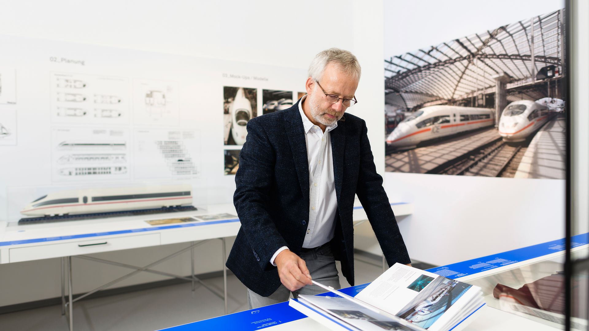 Mann blättert durch Ausstellungsbuch