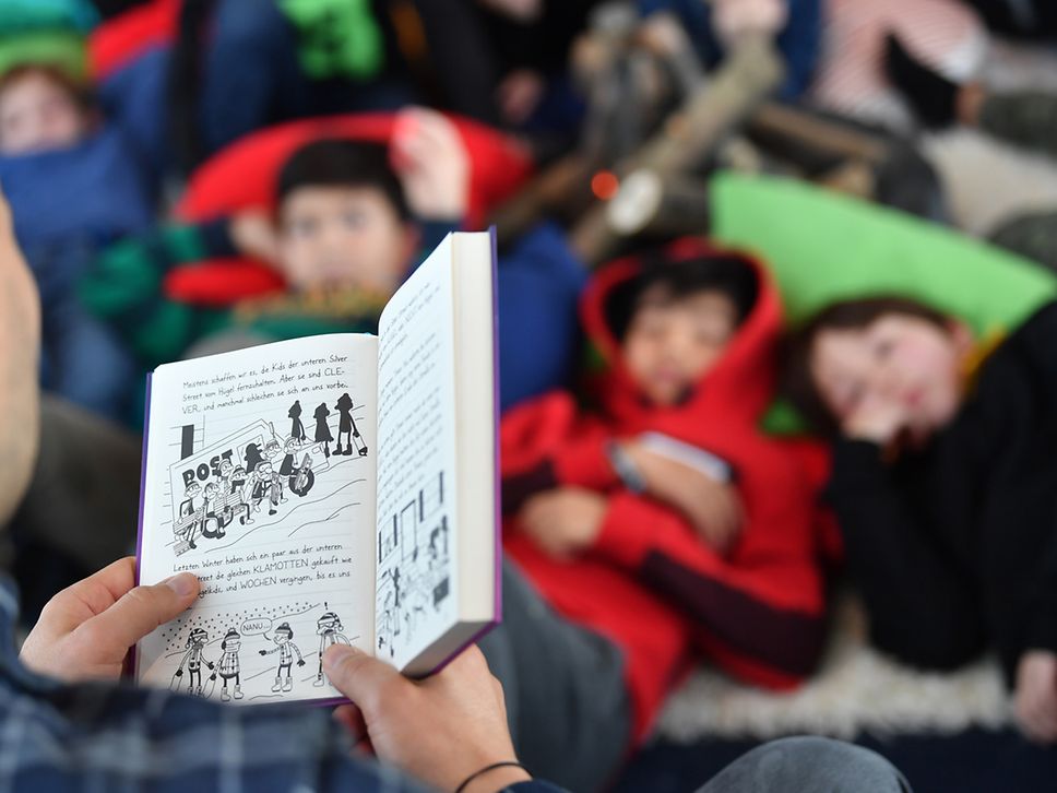 Mann liest Kindern vor