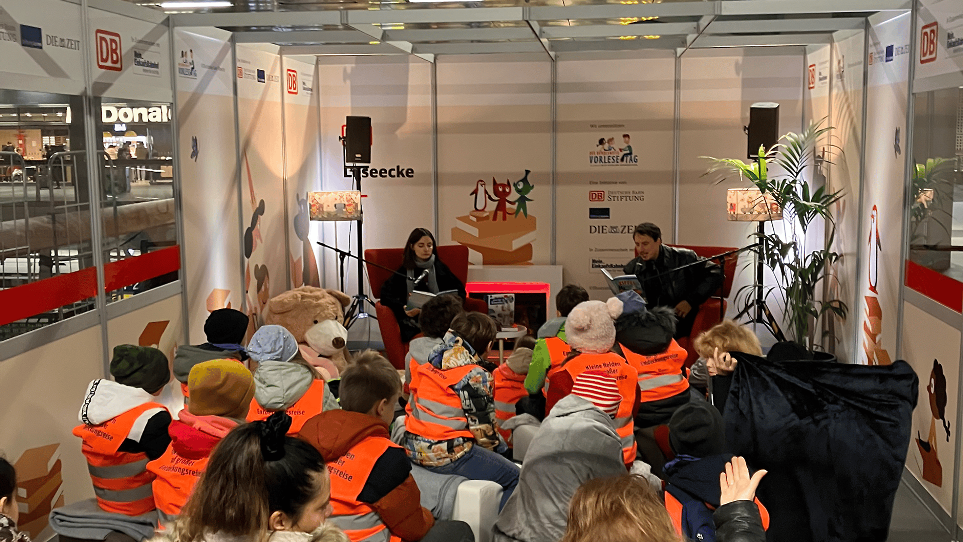 Impression Vorlesetag - Gruppe von Kindern sitzen auf dem Boden und ihnen wird vorgelesen